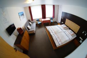 Blick in ein Schlafzimmer mit Bett und Sofa in der Unterkunft Hotel Werdumer Hof in Werdum