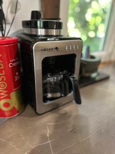 a coffee maker sitting on a counter next to a cup at Park Poleski - Sosnowe Zacisze in Grabniak