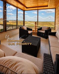a screened in porch with furniture and a view of a field at Villa Al Wesam in Amman