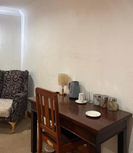 a wooden table with a lamp and a chair at Tsheryl's Residence in Centurion
