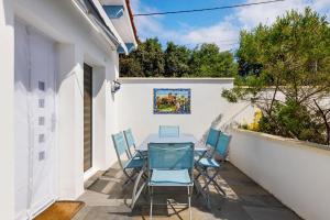 a patio with a table and chairs on a white wall at Villa Sandra - Le Verdon, Medoc in Le Verdon-sur-Mer