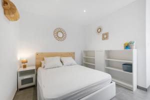 a white bedroom with a bed and white shelves at Villa Sandra - Le Verdon, Medoc in Le Verdon-sur-Mer