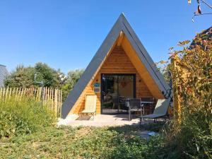 a small wooden house with a pitched roof at LES CHALETS DE COYRON. in Coyron