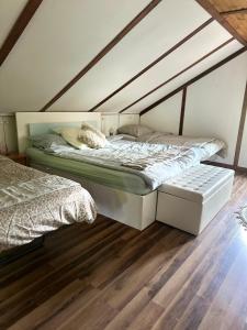 a bedroom with two beds and a wooden floor at Park Poleski - Sosnowe Zacisze in Grabniak