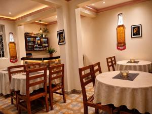 a restaurant with tables and chairs and a bar at Grand View Hotel in Fort Portal