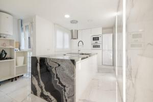 a kitchen with a large marble island in the middle at Apartamento Calafell Mar in Calafell
