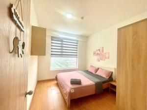 a bedroom with a bed with pink sheets and a window at Saigon Getaway Apartment Thu Duc in Ho Chi Minh City +22 photos