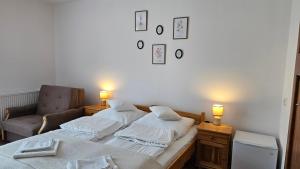two beds in a room with a chair and two lamps at Pensjonat Fluder in Jaszczurowa +41 photos