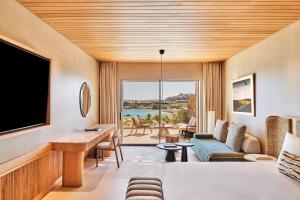a living room with a couch and a tv at Fouquet's Mykonos in Mikonos