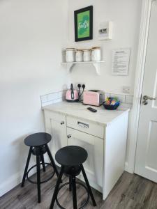 a small kitchen with two stools and a counter at The Lodge in Killarney +4 photos