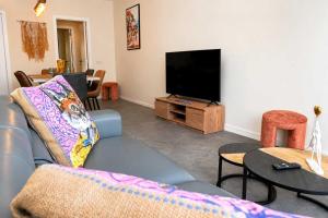 a living room with a couch and a flat screen tv at BEACH house in Westende-Bad
