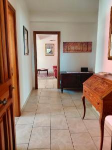 a hallway with a room with a bed and a table at Casa dei Nipotini con Posto Auto Riservato in Paganica