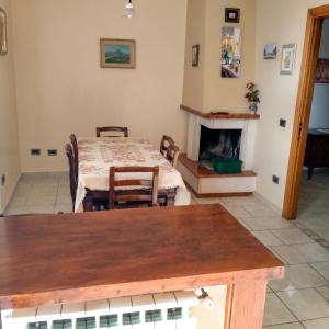 a dining room with a table and a fireplace at Casa dei Nipotini con Posto Auto Riservato in Paganica