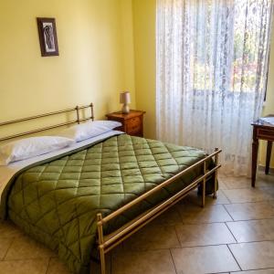 a bedroom with a bed and a table and a window at Casa dei Nipotini con Posto Auto Riservato in Paganica
