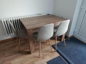 a wooden table with two chairs and a radiator at Chalúpka Liptov in Lúčky