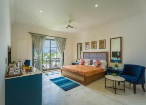 a bedroom with a bed and a blue chair at Tripli Hotels Blue Moon in Udaipur