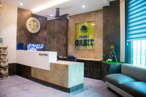 a lobby of a hotel orchid with a reception desk at Hotel Orbit in Parbhani