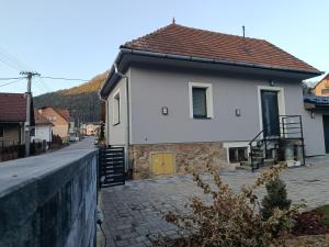 a white house with a yellow door on a street at Chalúpka Liptov in Lúčky