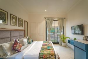 a bedroom with a bed and a sink and a window at Tripli Hotels Blue Moon in Udaipur