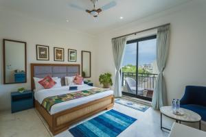 a bedroom with a bed and a balcony at Tripli Hotels Blue Moon in Udaipur
