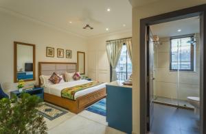 a bedroom with a bed and a bathroom at Tripli Hotels Blue Moon in Udaipur +69 photos
