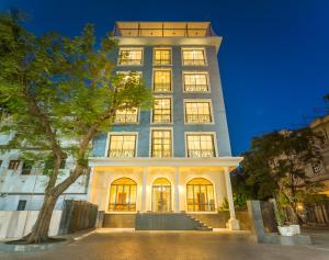 a tall building with a tree in front of it at Tripli Hotels Blue Moon in Udaipur