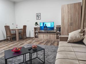 a living room with a couch and a table and a tv at Apartmani Peric Bogatic in Bogatić +5 photos