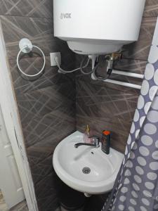 a bathroom with a toilet and a white sink at Apartmani Peric Bogatic in Bogatić