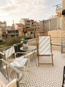 a patio with chairs and a table on a balcony at Retro Apartment Patras in Patra