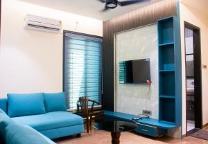 a living room with a blue couch and a tv at Hotel Orbit in Parbhani +34 photos