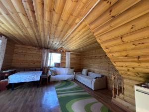 a living room with a wooden ceiling and a couch at Деревянный домик in Dolinka