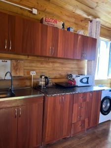 a kitchen with wooden cabinets and a counter top at Деревянный домик in Dolinka