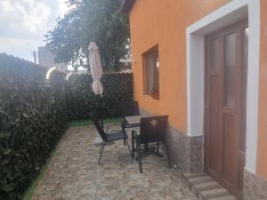 a patio with a table and chairs and an umbrella at Casa Florentina in Făgăraş