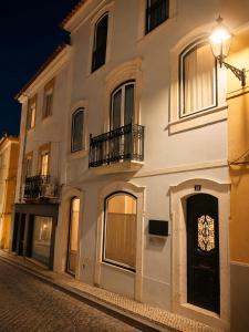 a large white building with a clock on the door at CASA d’OLIVENÇA in Elvas