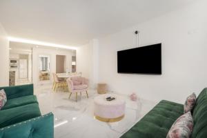 a living room with a green couch and a tv at Apartamento Calafell Mar in Calafell +21 photos