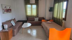 a living room with two beds and a couch at Anemos House Sykia Halkidiki in Sykia Chalkidikis