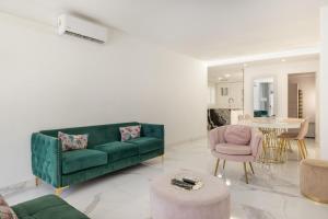 a living room with a green couch and a pink chair at Apartamento Calafell Mar in Calafell