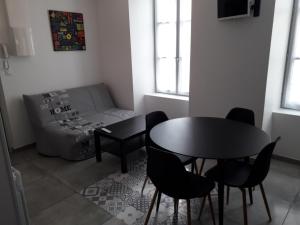 a living room with a table and chairs and a couch at cosy à Blois in Blois