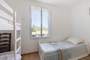a bedroom with a bunk bed and a window at La Maison Familiale in Commequiers