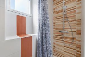 a bathroom with a shower with a shower curtain at La Maison Familiale in Commequiers +18 photos