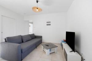 a living room with a couch and a tv at La Maison Familiale in Commequiers