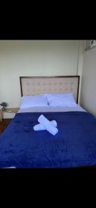 a pair of white towels laying on a blue bed at Mystical Hidden Farmhouse in Camiguin