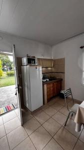 a kitchen with a refrigerator and a table and a chair at Espacio Canela monoambiente in Ramallo
