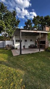 a white house with a patio and a yard at Espacio Canela monoambiente in Ramallo