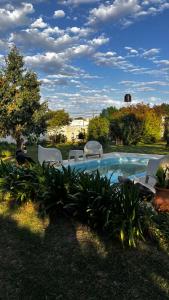 a group of chairs sitting around a swimming pool at Espacio Canela monoambiente in Ramallo
