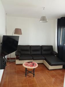 a living room with a black couch and a table at Ze Carlos Simoes in Mira