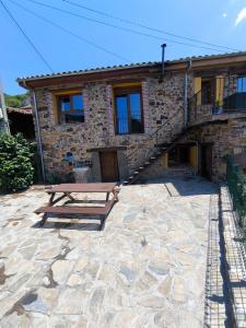 a stone house with a picnic table in front of it at El Balcón de Urbiés in Mieres