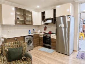 a kitchen with a stainless steel refrigerator and a dishwasher at Golden palm in Itʼkhvisi