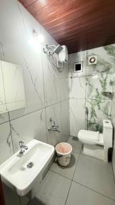 a white bathroom with a sink and a toilet at The Royal Pool Resort-Swimming Pool Resort, Varkala in Varkala