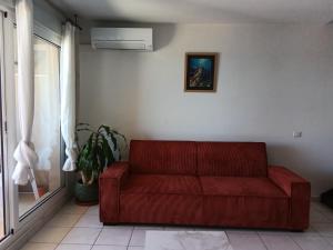 a red couch sitting in a living room at Maria beach in San-Nicolao +1 photo
